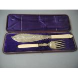 A pair of Victorian silver plated fish servers with carved ivory handles and foliate engraved