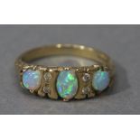 An opal and diamond ring in 9ct gold the graduated oval and circular cabochon's set in line and