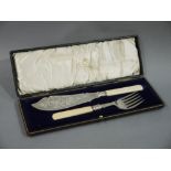 A pair of silver plated fish servers with foliate engraved blades, ivory handles,