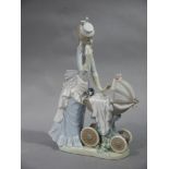 A Lladro figure of a mother pushing a child in a pram,