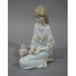 A Lladro figure of a young girl, kneeling with a basket and flowers,