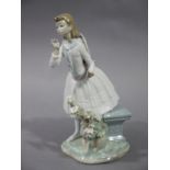 A Lladro figure of a young girl standing beside a bench with floral encrusted branch,