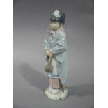 A Lladro figure of a young Chinese girl carrying a bag,