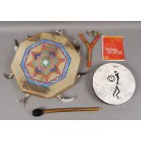 An octagonal painted skin tribal shaman style drum and beater, 44cm; a Healing drum and guide,