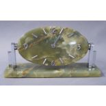 An Art Deco style onyx desk clock, the oval dial with Arabic numerals at 12, 3, 6 and 9,