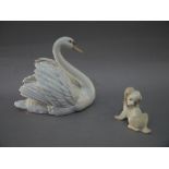 A Lladro figure of a swan, 18cm high; a Spanish figure of a dog,