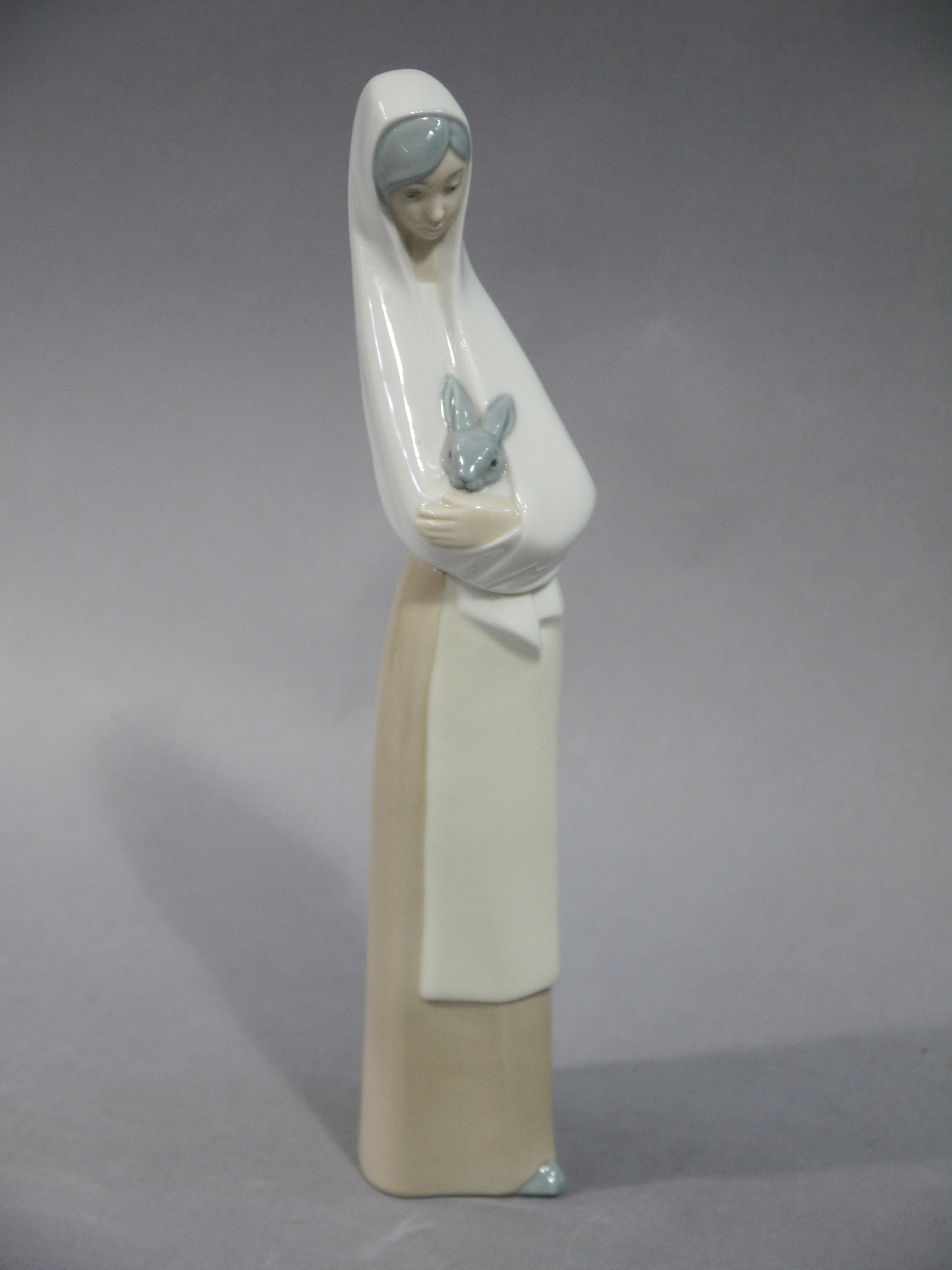 A Nao figure of a woman holding a rabbit,