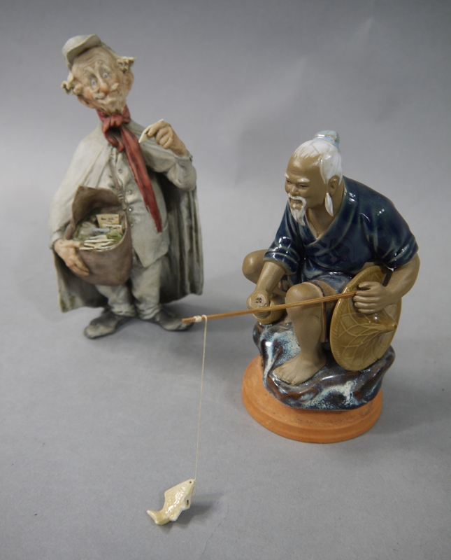 An Italian bisque porcelain figure of a postman, 18cm; a porcelain figure of a Chinese fisherman, - Image 2 of 2