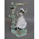 A Lladro figure of a young woman on a swing with dog at her feet,