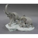 A Lladro group of three elephant, bull, female and calf on a moulded shaped base,