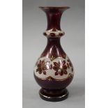 A Victorian ruby flashed vase with everted rim collar and band of stylised flower heads on a white