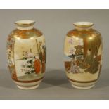 A pair of Japanese Satsuma pottery baluster vases each decorated with panels of figures in tree