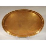 H Barnes - The Forge, Thornton le Dale, a hammer textured oval copper tray with rope twist border,