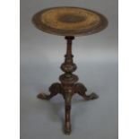 A Victorian walnut tripod table having foliate carved rim,