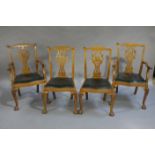 A set of four walnut Chippendale style chairs with pierced splats and hide drop-in seats on