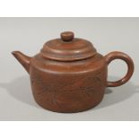 A Chinese red ware teapot of squat and cylindrical form with slightly domed cover, short spout,