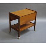 A teak trolley with single drop leaf and under tier on castors