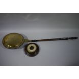 A brass and copper warming pan on a turned fruit wood handle,