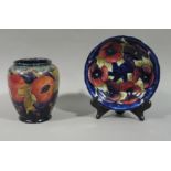 A Moorcroft 'Pomegranate' pattern vase, 16cm high; a Moorcroft 'Pansy' pattern circular dish, 18.