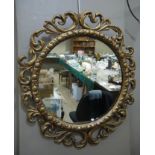 A circular wall mirror with gilt pierced foliate frame