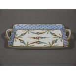 An early 20th century Sévres style pin tray rectangular with twin handles and painted with floral