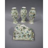 A set of three Chintz style chamfered baluster vases with hexagonal necks and feet,