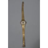 A lady's wristwatch by Nisus in an 18ct gold case on an integral engine turned bracelet,