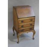 A lady's reproduction burr walnut writing bureau having a fitted interior,