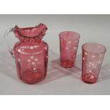 A Victorian cranberry glass jug and pair of matching tapered cylindrical beakers,