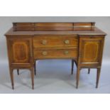 A Edwardian mahogany and satinwood banded sideboard having a short raised back inverted breakfront