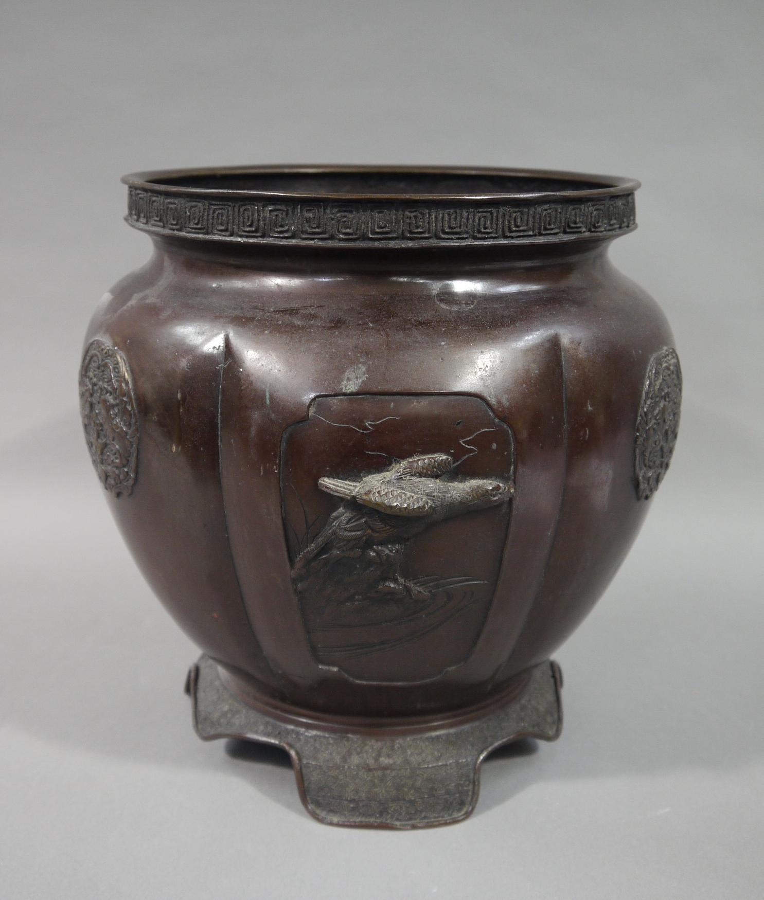 A Japanese bronze jardiniere of circular lobed outline decorated in relief with panels of waterfowl