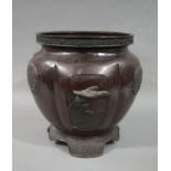 A Japanese bronze jardiniere of circular lobed outline decorated in relief with panels of waterfowl