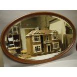 A mahogany oval bevelled wall mirror