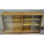 A sapele mahogany and glazed bookcase with sliding glass doors on plinth base