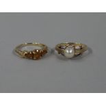 Two dress rings both in 9ct gold including a 6mm cultured pearl single stone ring and a three stone