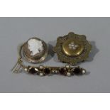 Three Victorian brooches all in 9ct gold including a shield brooch gypsy set to the centre boss