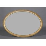 A giltwood and gesso oval wall mirror with bevelled plate, gadroon moulded frame, beaded slip,