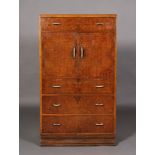 An Art Deco style walnut and amboyna veneered tallboy with ivorine and white metal handles,