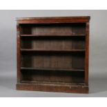 A Victorian walnut veneered open bookcase with shallow frieze above a pair of leafy corbels,