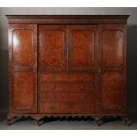 A George III style plum pudding mahogany breakfront wardrobe, the flared cornice,