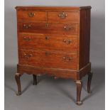 A George III oak chest on stand having a moulded cornice above two short and three long graduated