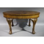 An oval walnut occasional table with deep apron and on shell carved and tied cabriole legs on