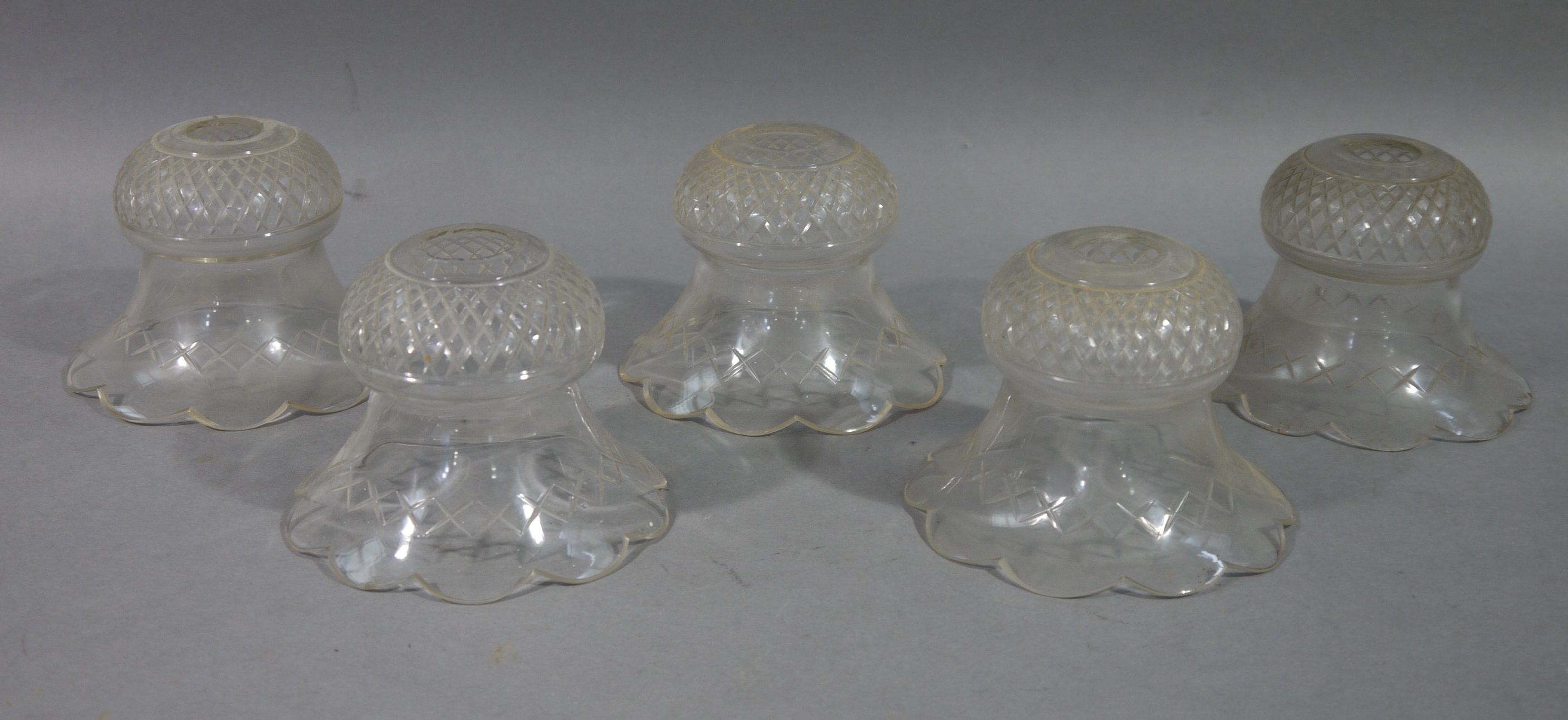 A set of five Edwardian cut glass light shades of thistle shape with scalloped rim, 13.