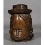 An African tribal softwood mask of helmet form, carved as a full head, the face with high forehead,