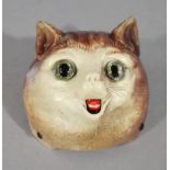 A celluloid table top bell moulded as a cat's face with glass eyes,