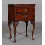 A reproduction mahogany bedside cabinet having a slide and two cockbeaded drawers,