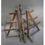 A set of three brown painted estate made game hangers of A frame,