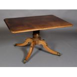 A Regency mahogany table, the rounded rectangular figured top above a central turned column,