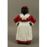 A reproduction painted cast iron money bank figure of a black woman wearing spotted red headscarf