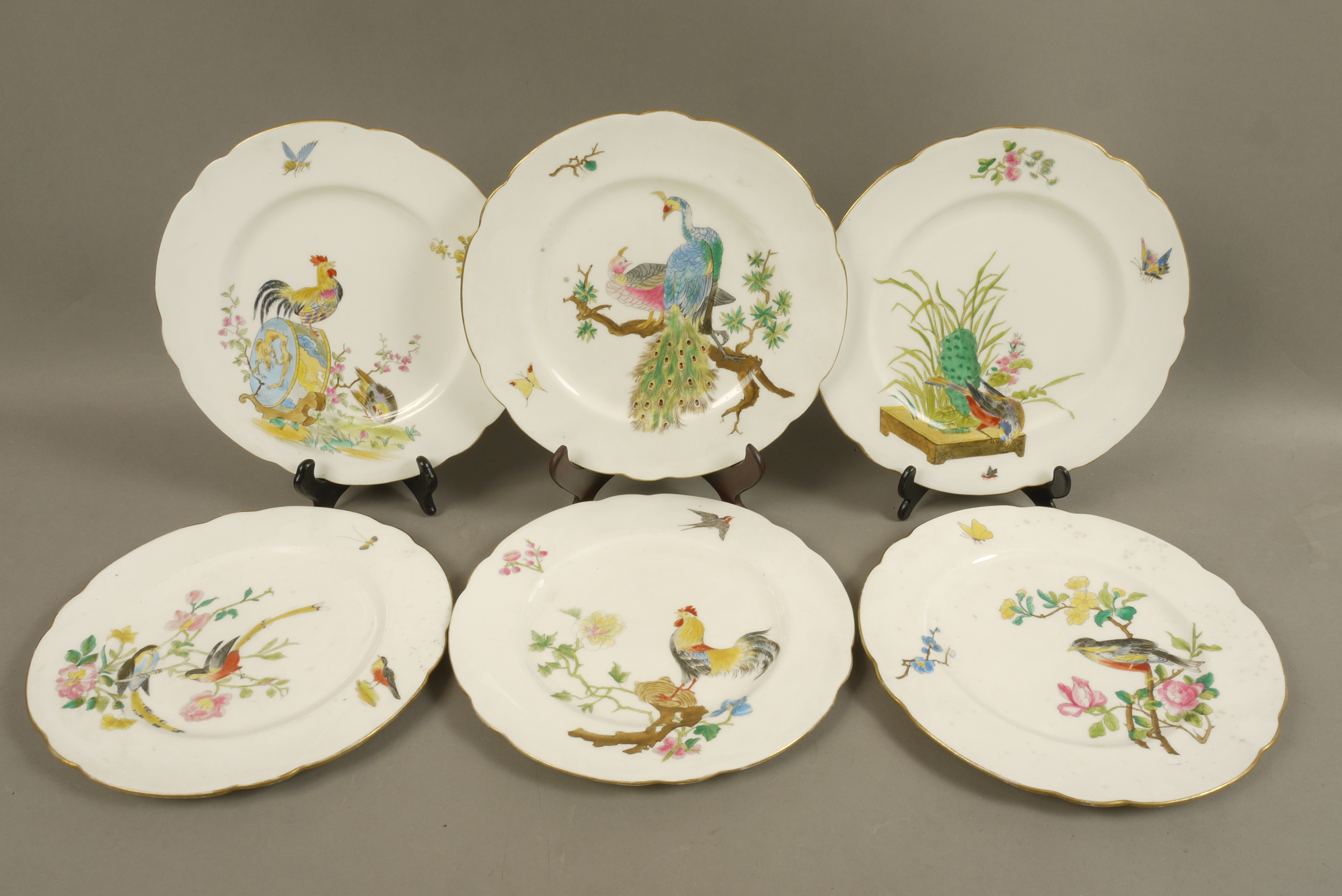 A set of six shaped circular cabinet plates each printed and painted with a different bird and